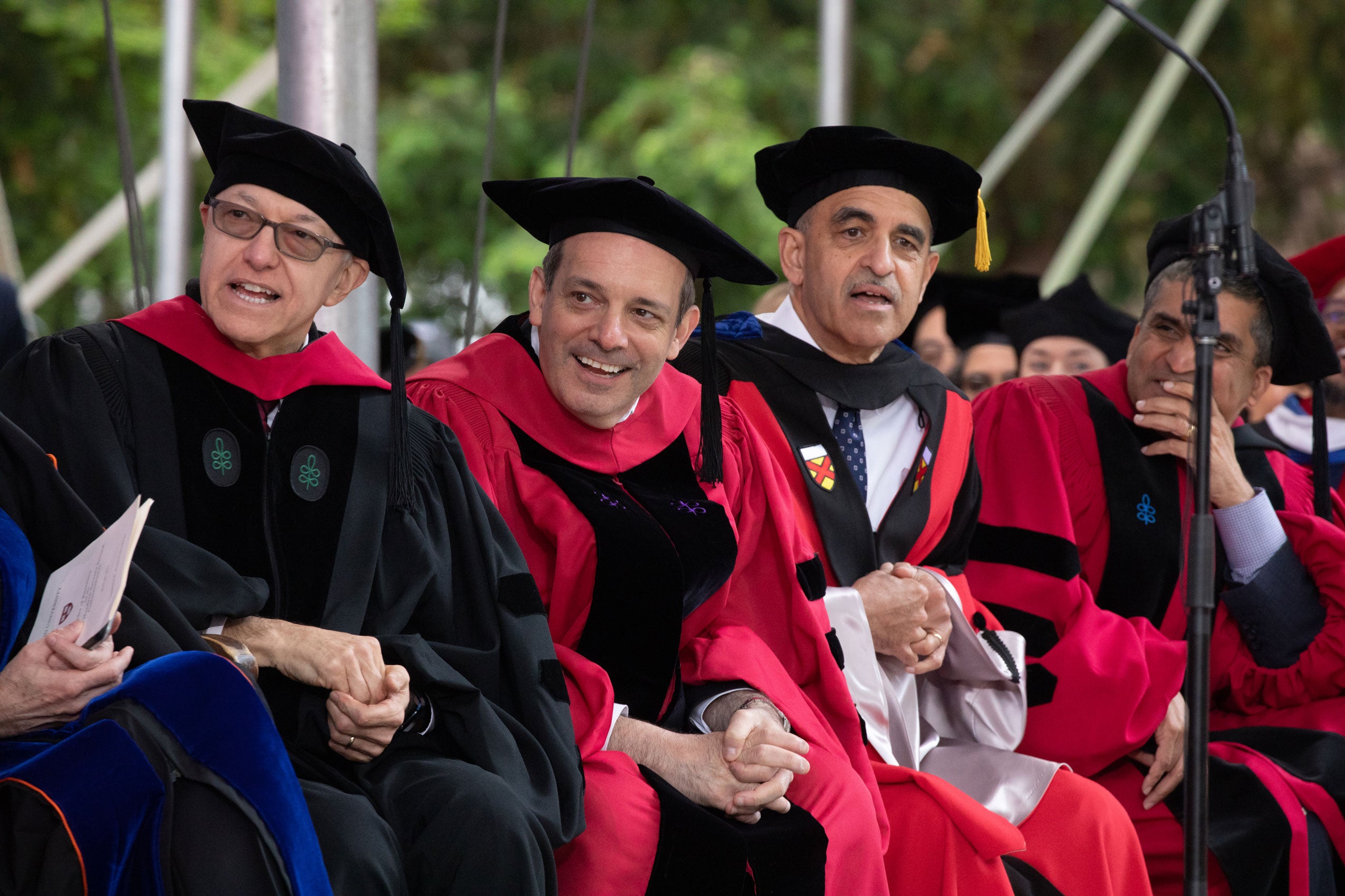 Dean Manning and several others lean to watch Tom Hanks give the Commencement address