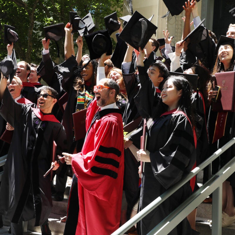 Professor I. Glen Cohen cheers along with the student in his section as they pose for a section photo on the steps of Langdell