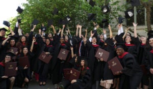 Graduates toss caps into the air
