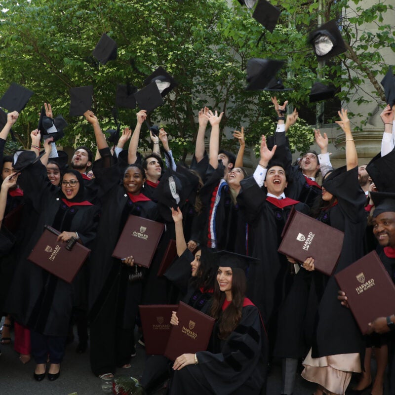Graduates toss caps into the air