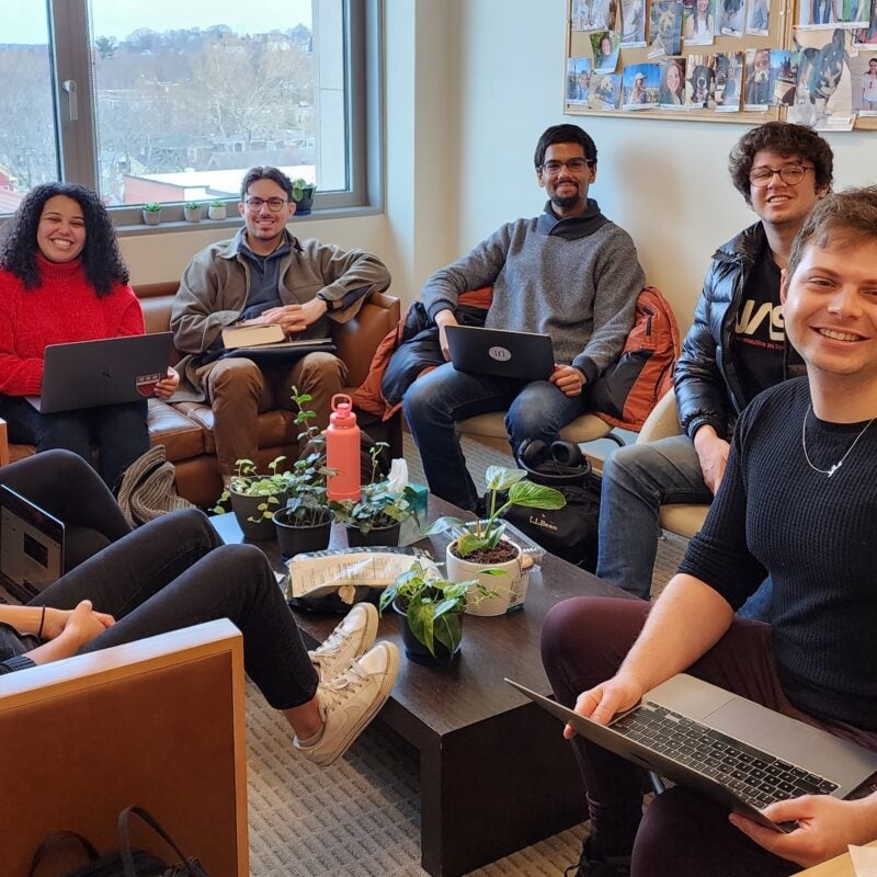 TAP students sit in a circle with their laptops
