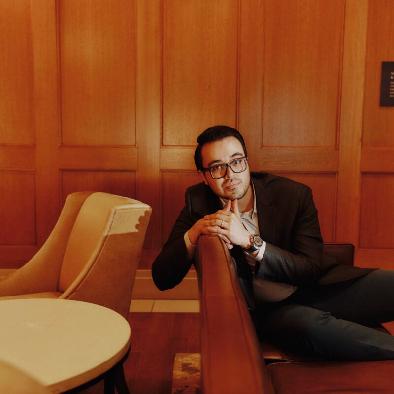 Jimenez-solis sitting on a couch in a room with wooden panels