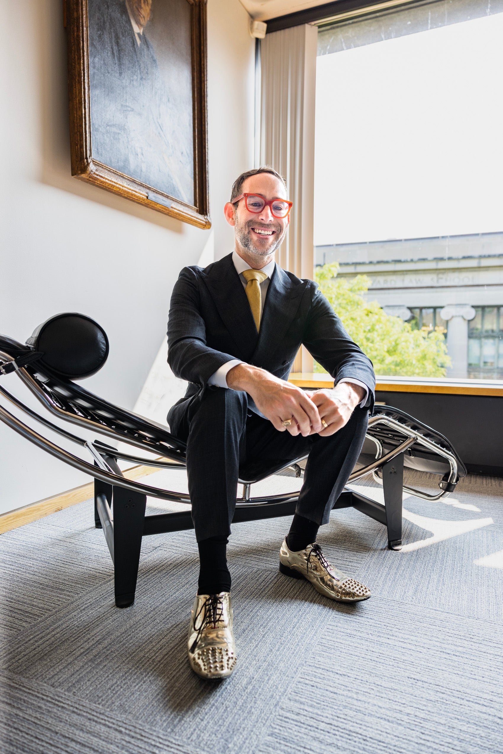Glenn Cohen sitting on a modern metal chair in his office