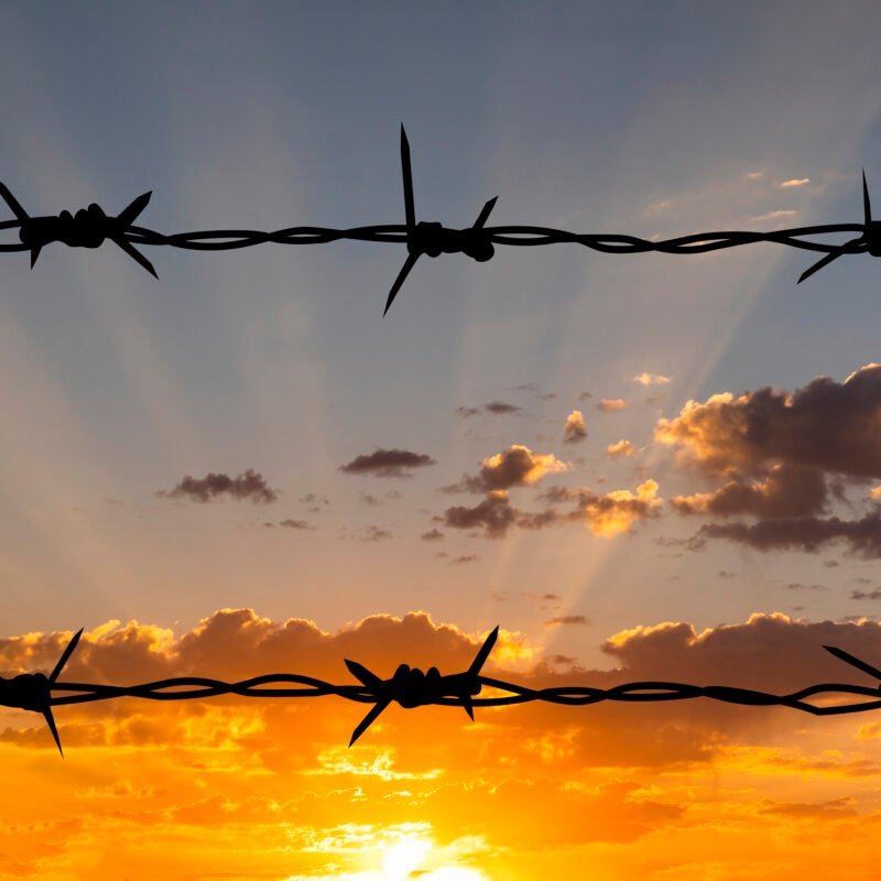 Barbed wire against a sunset