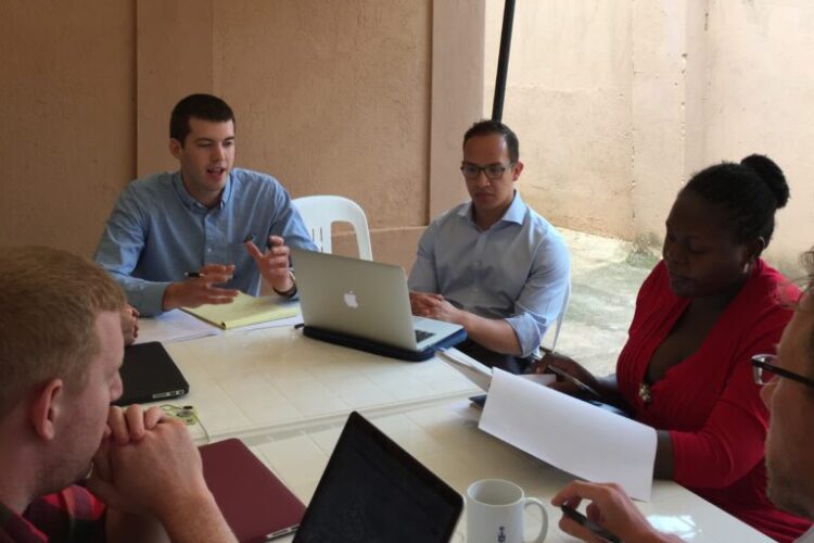 students and clients work at a table outdoors