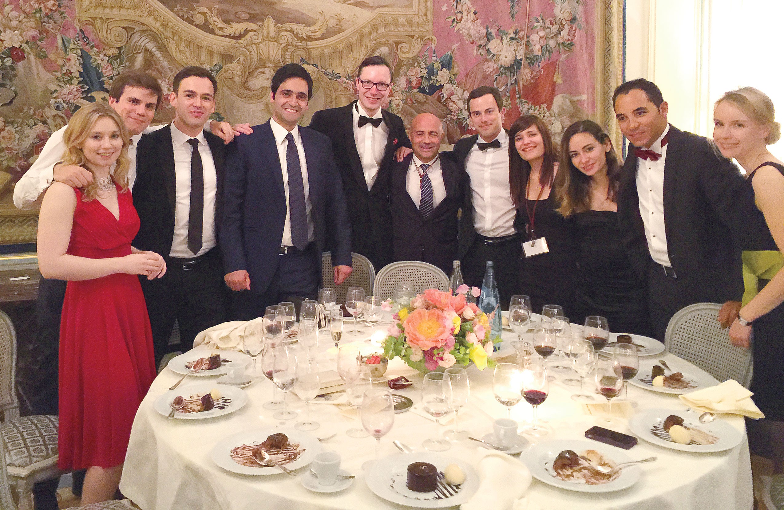 large group of people around a dinner table embracing