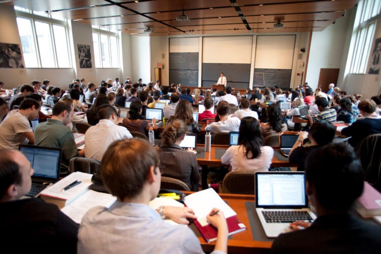 A large classroom of students listen to a lecture