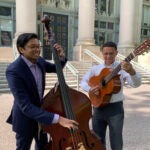 Cosimo Fabrizio and Shaan Pandiri playing instruments on Langdell stairs