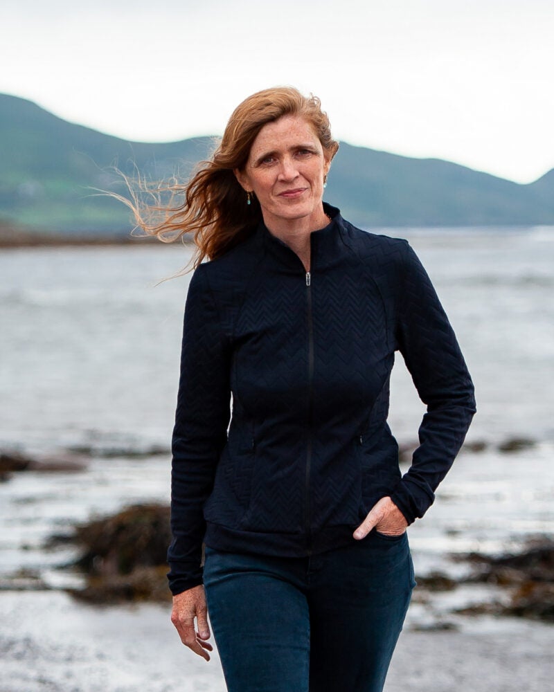 A woman walking toward the camera on near a beach
