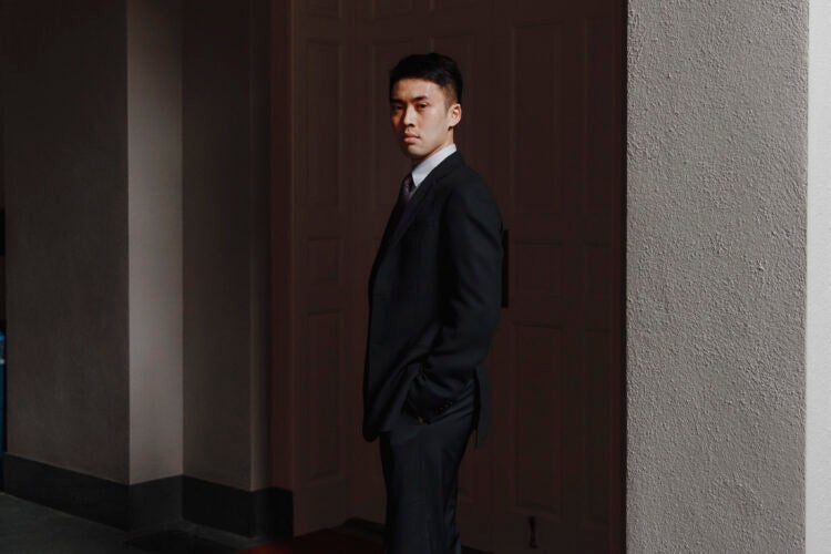 A man stands next to a white column