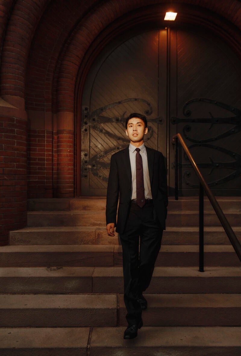 A man walks down a short exterior set of stairs.