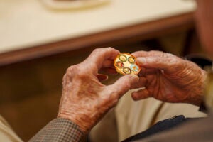 Hands of a man holding a gold coin.