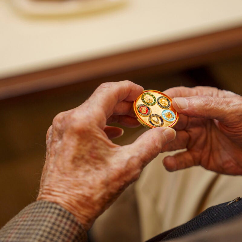 Hands of a man holding a gold coin.