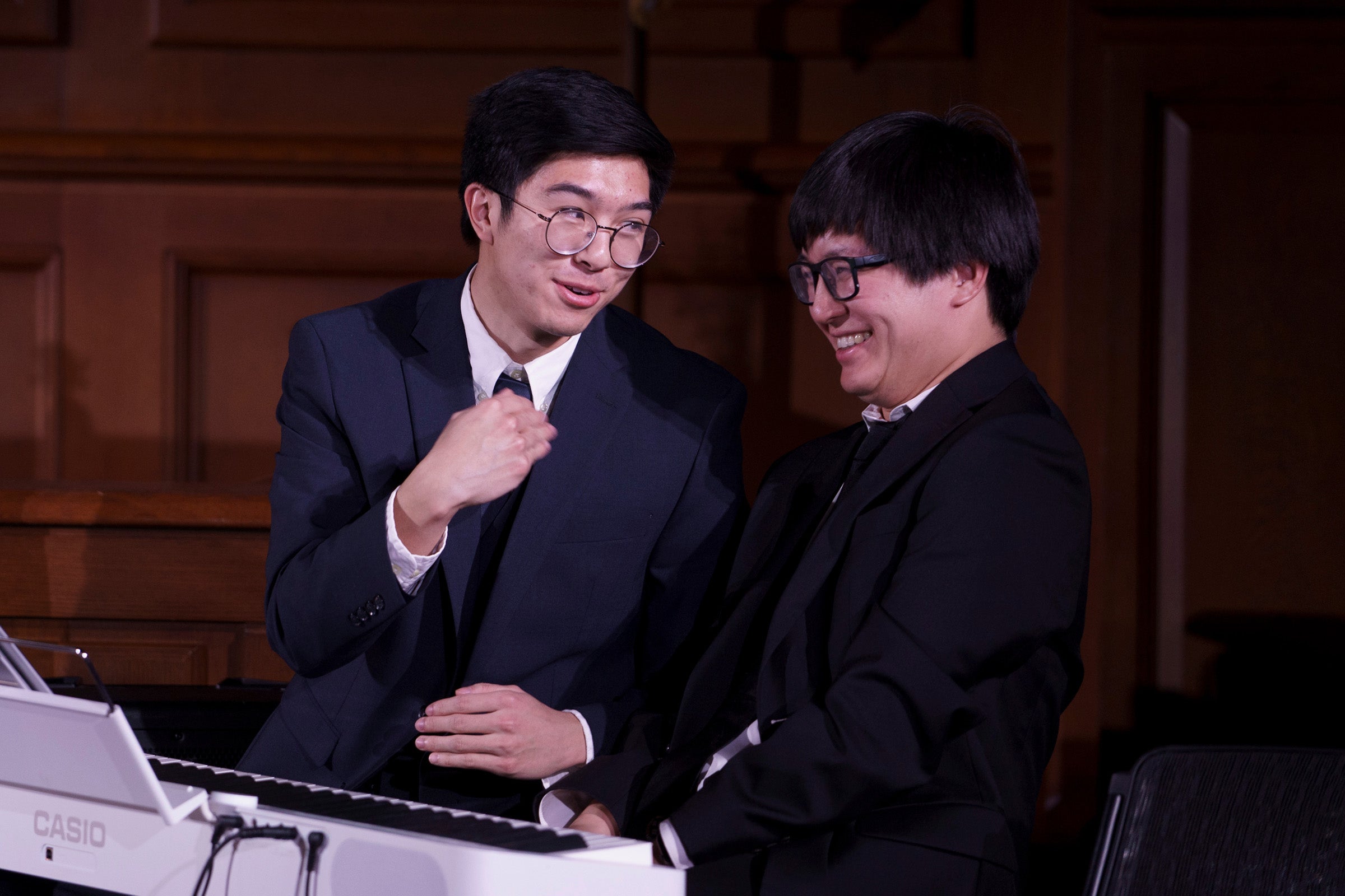 Two people seated at a piano.