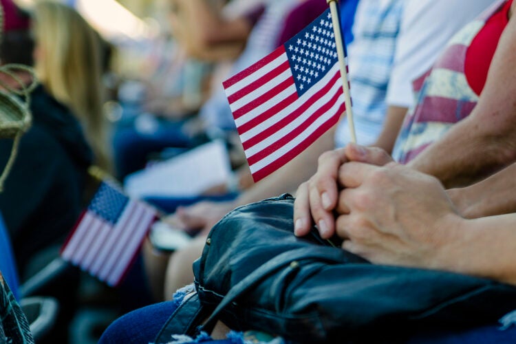 Person holding small American flag.