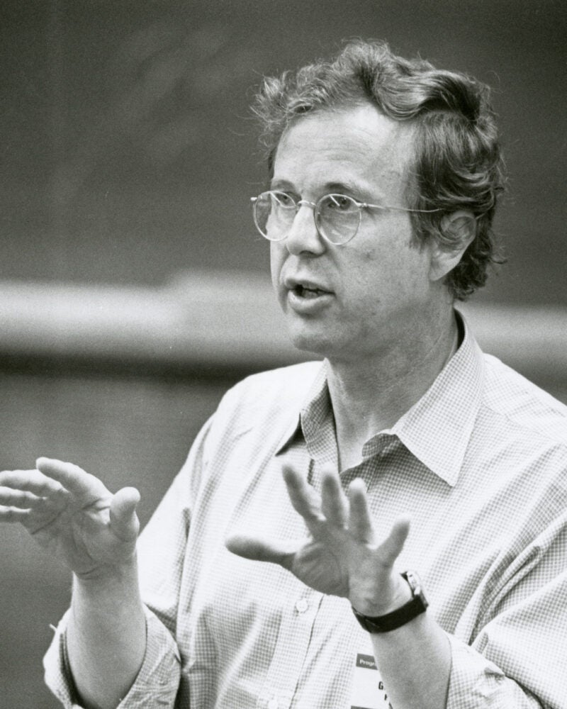 A man gesturing with both hands as he is speaking