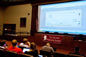 Students watching the audio broadcasts on projector screen
