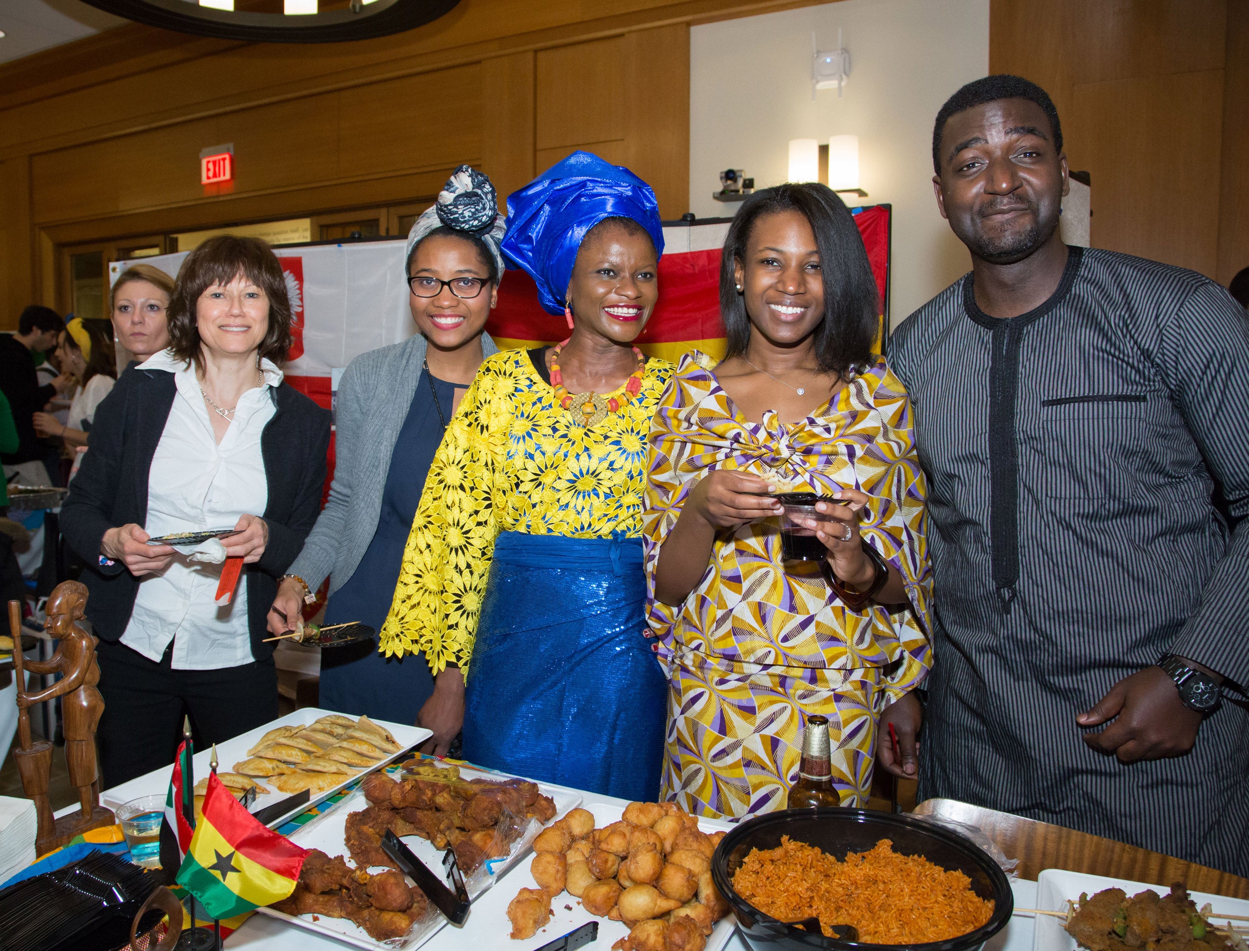 A group of people posing behind a table full of food