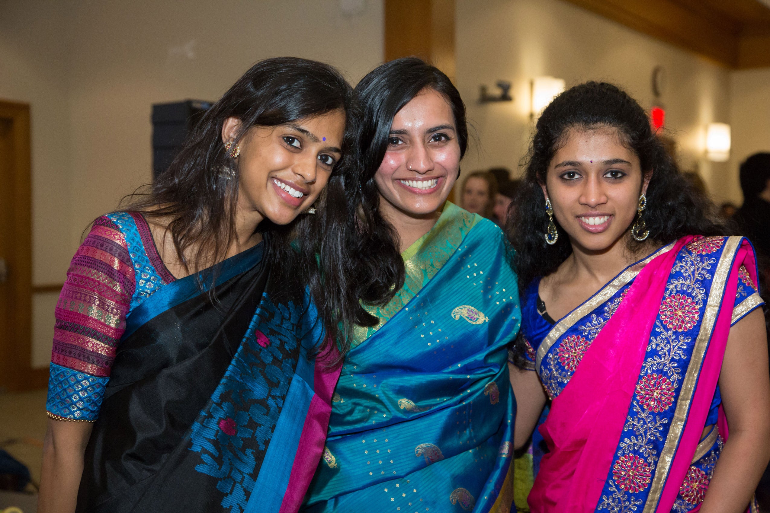 A group of three women posing together