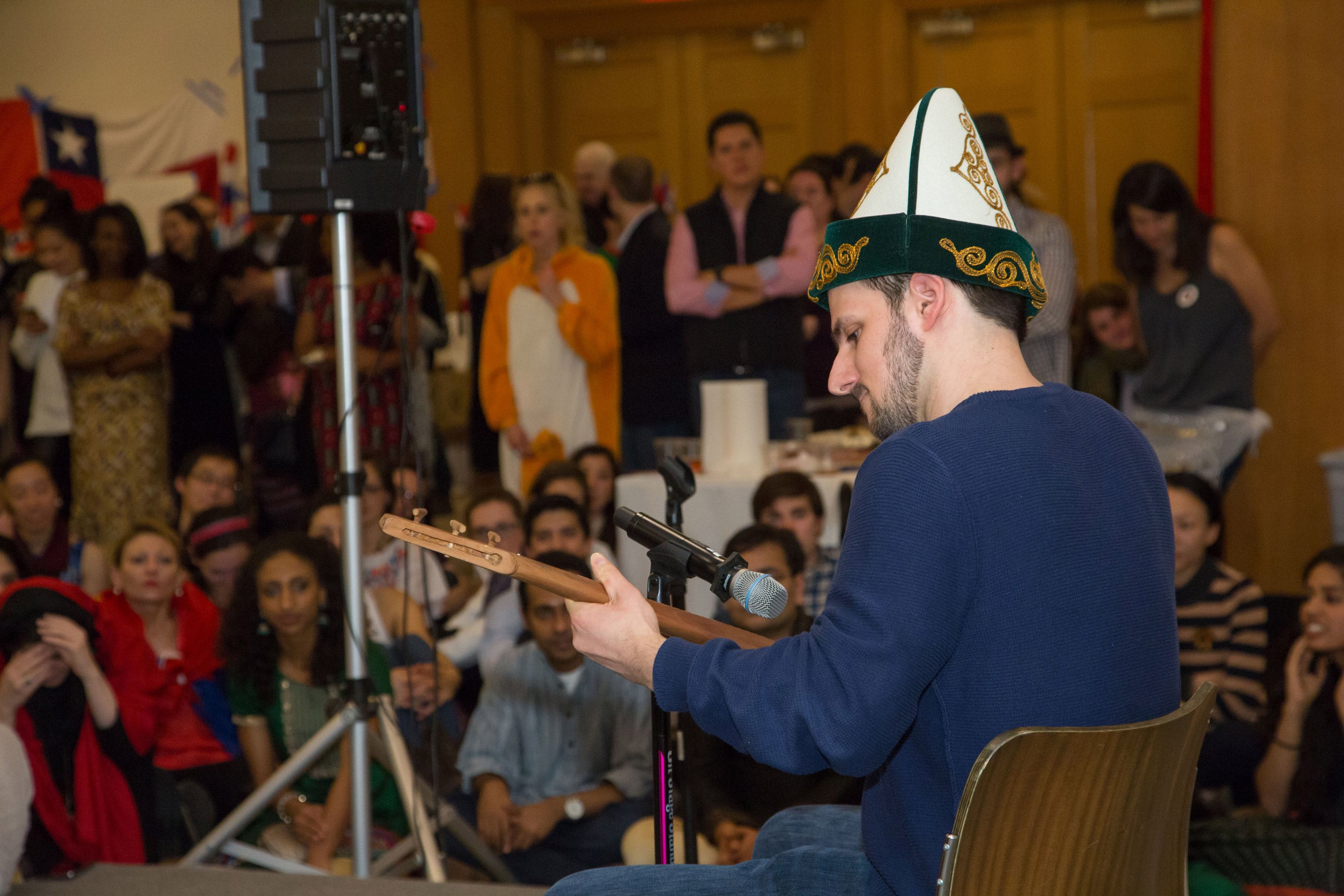 A man playing an instrument on stage in front of an audience