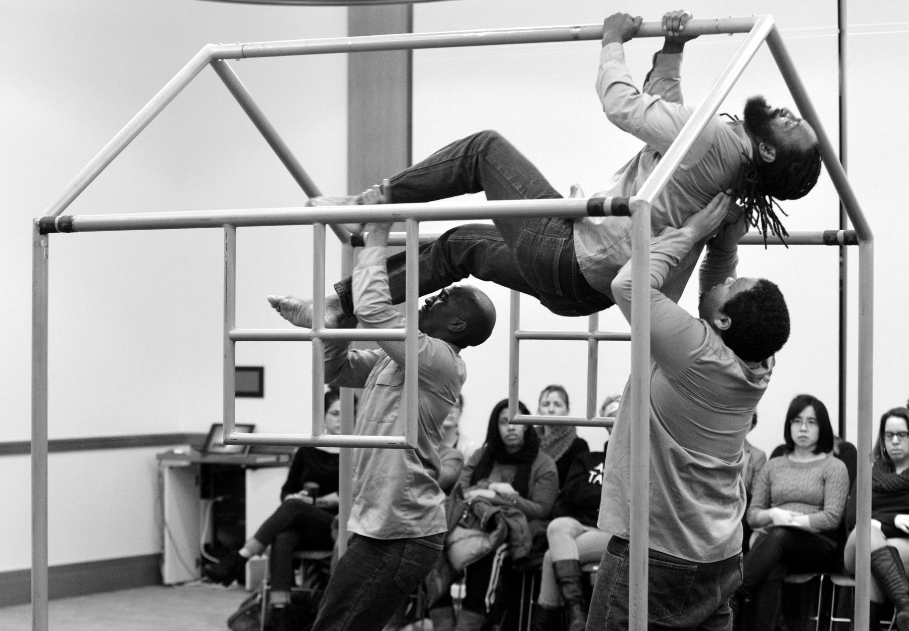 Three men performing with a house shaped prop