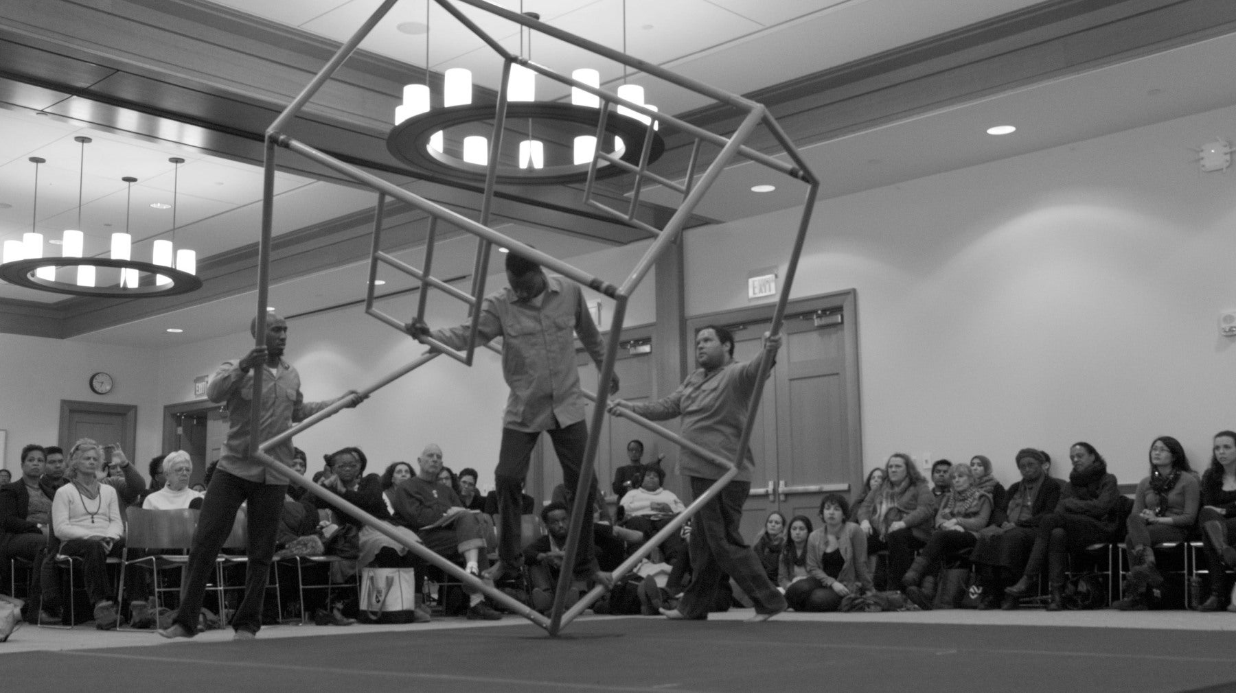 Three men performing with a house shaped prop