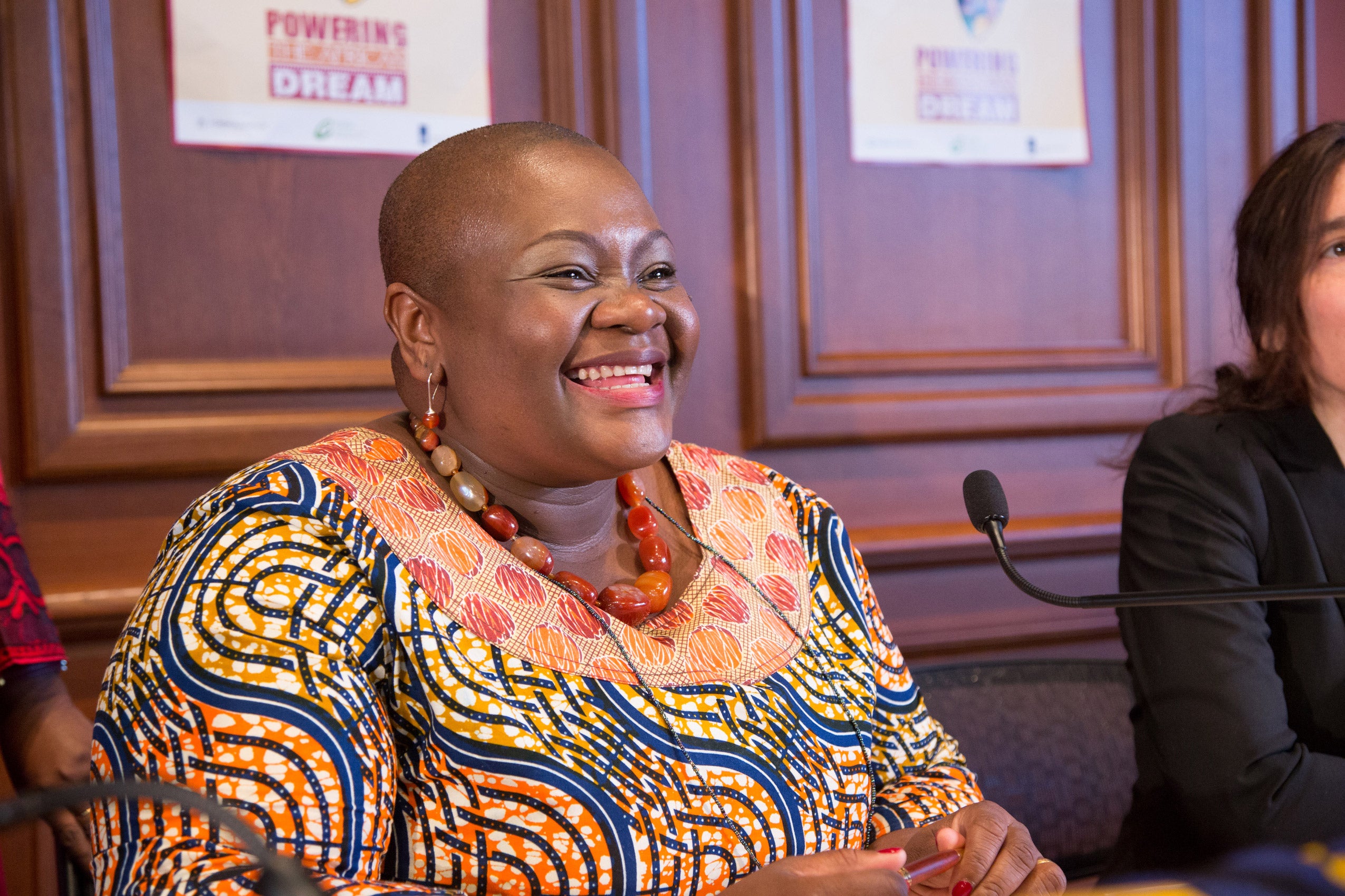A woman seated behind a microphone