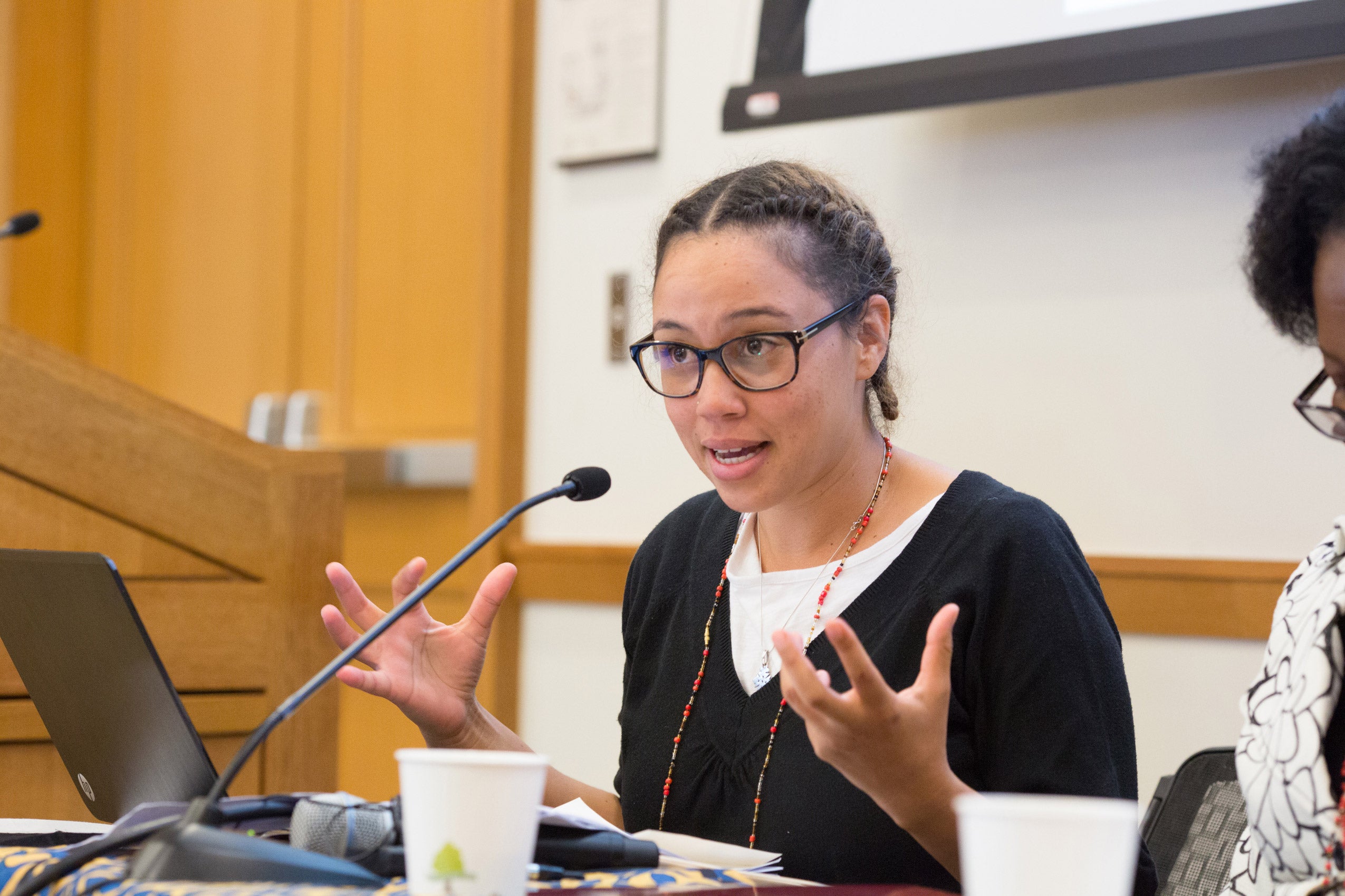 A woman sitting and speaking into a microphone