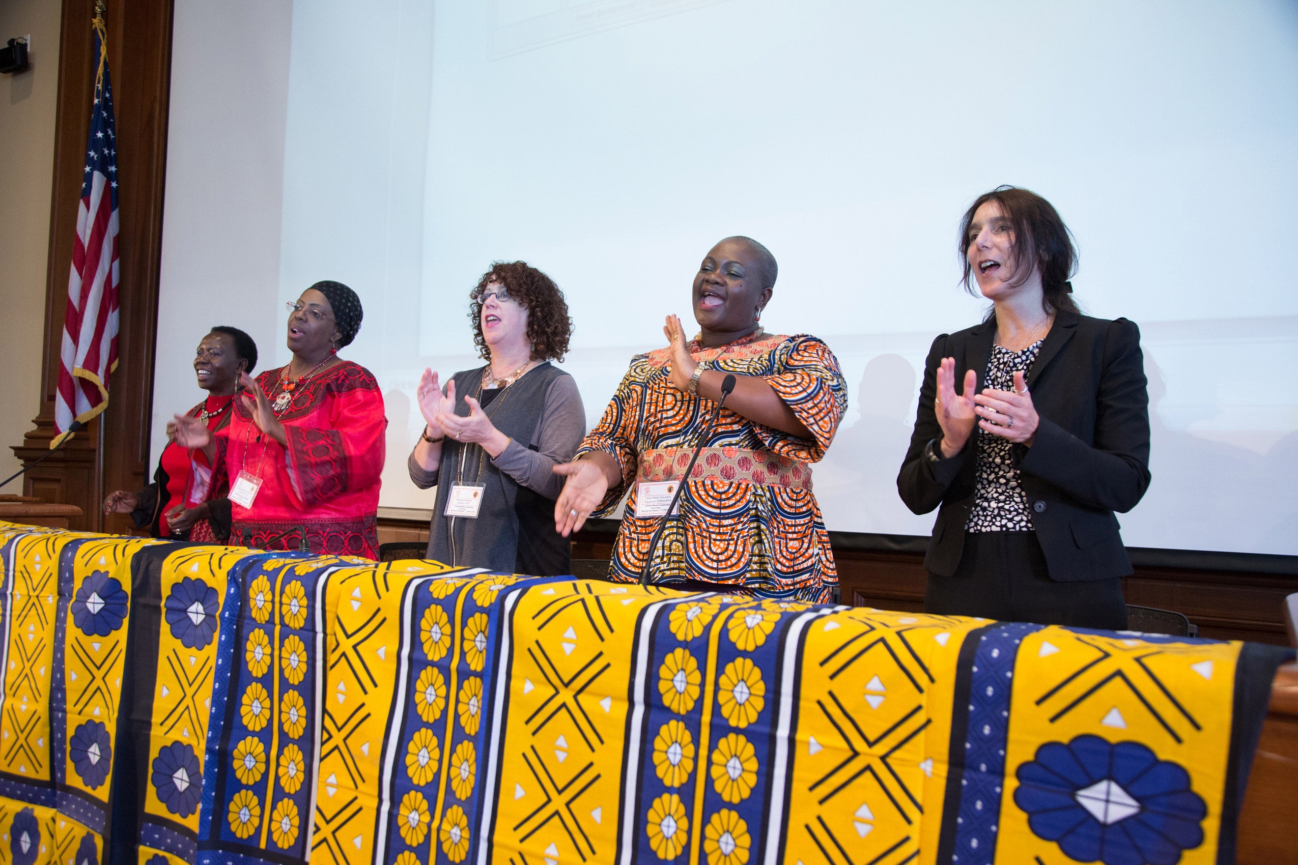 A group of women singing and clapping