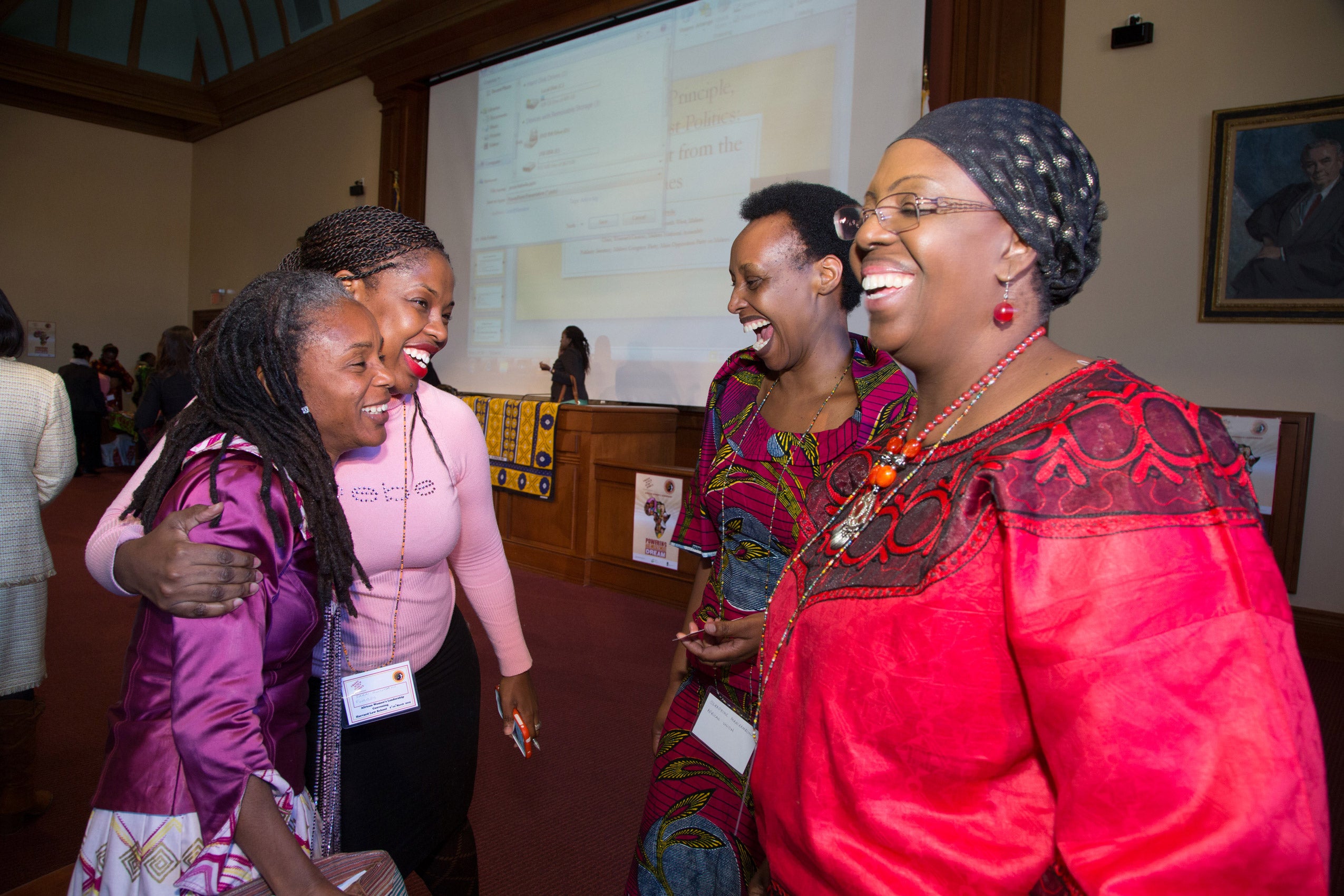 A group of women standing in a circle and laughing
