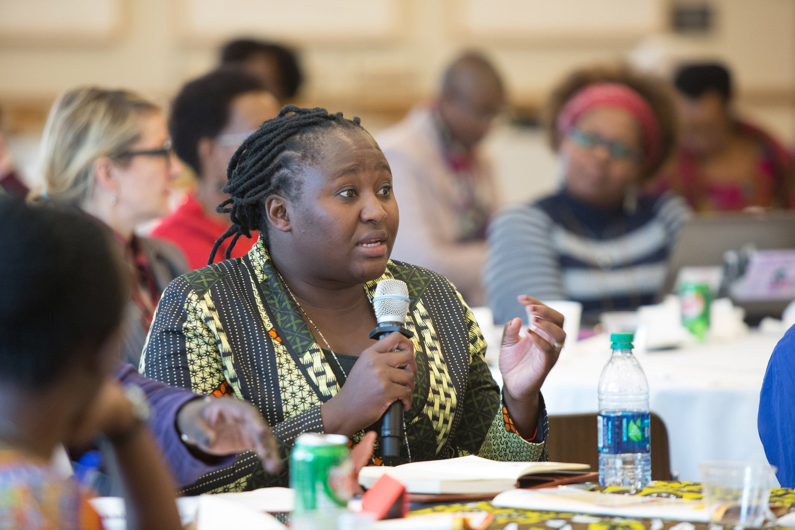 A woman sitting and speaking into a microphone