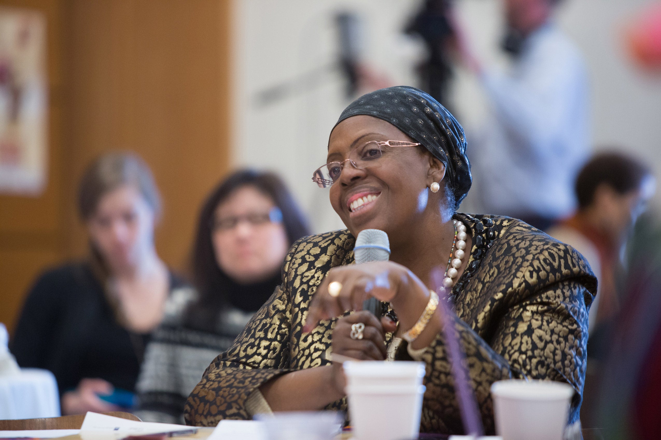 A woman seated and holding a microphone