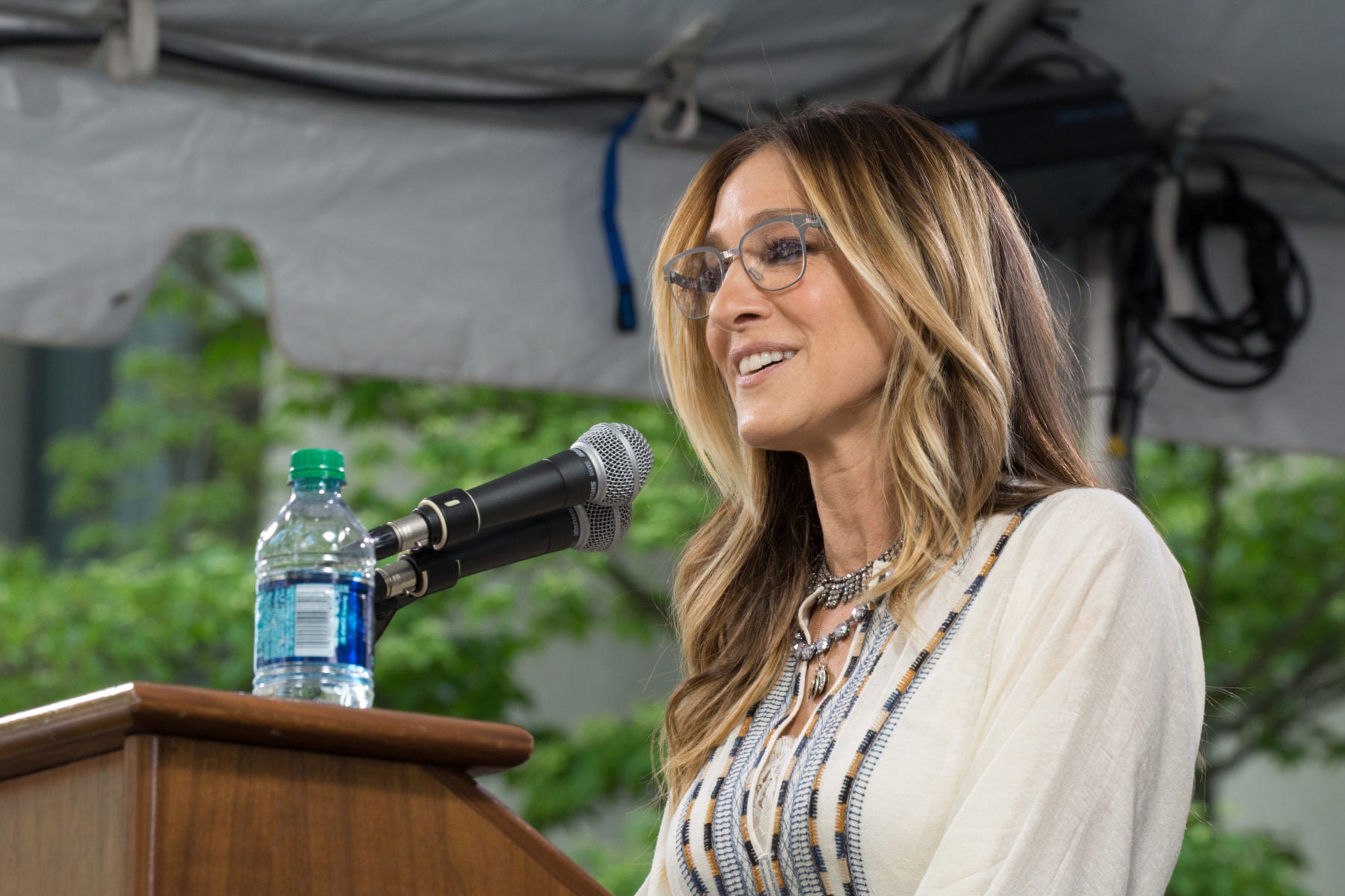 Sarah Jessica Parker speaking outside at a podium