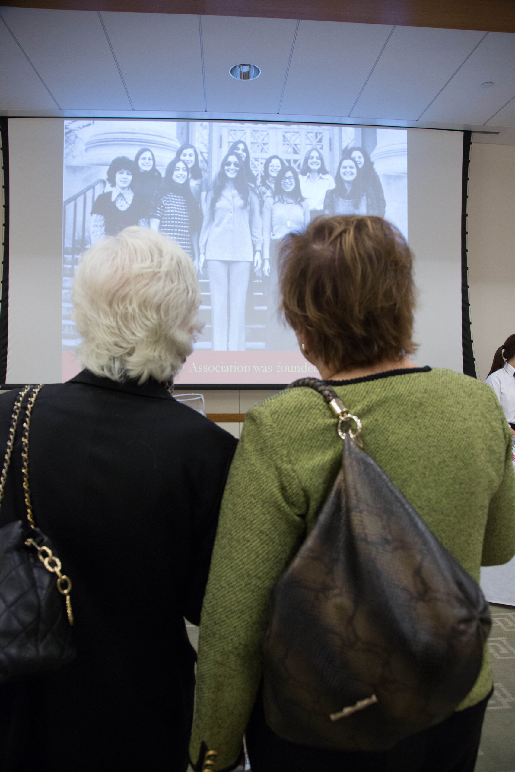 The back of two heads looking at a slideshow image