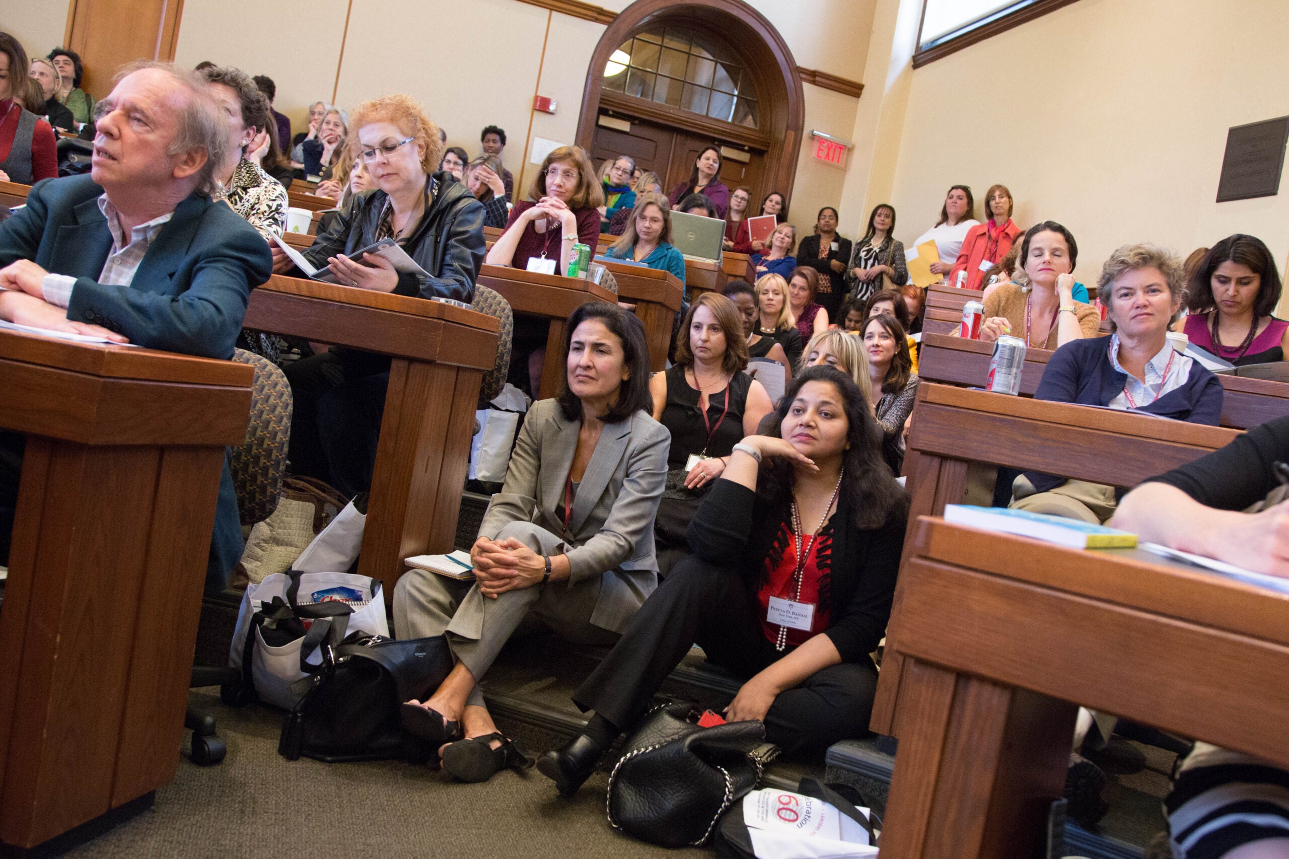 classroom packed with people, some sitting in the aisles