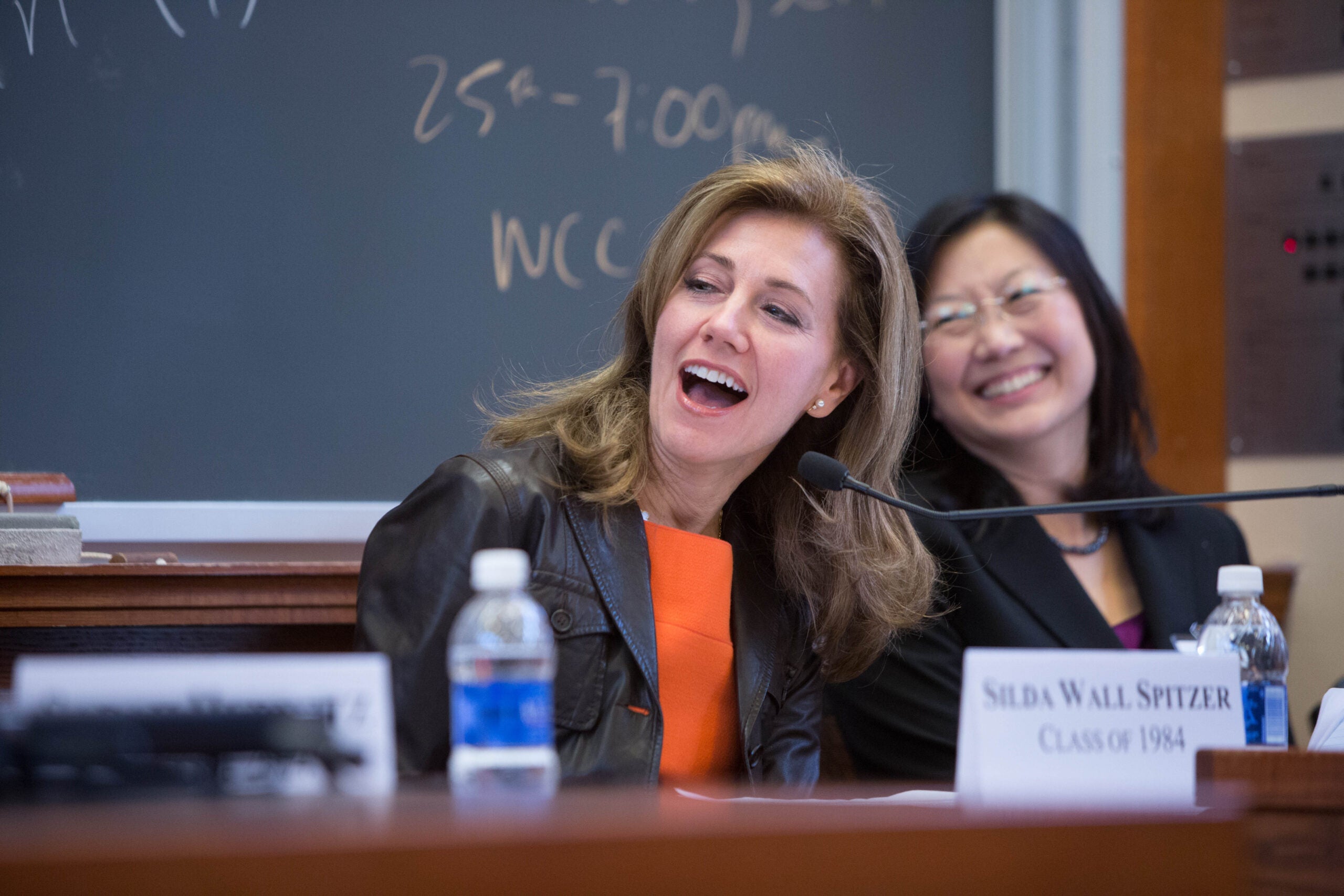 two women laughing on a panel