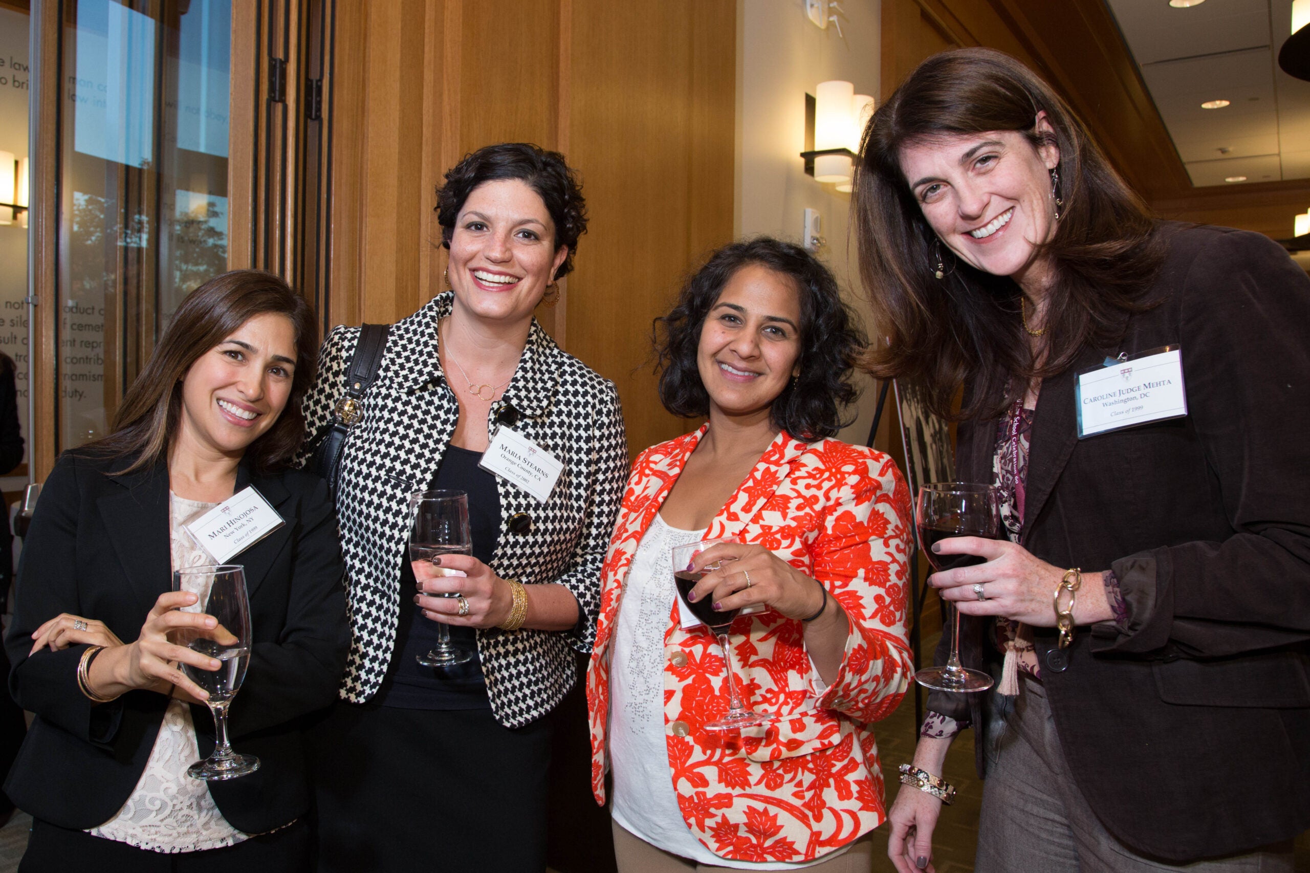 Group of four people smiling together holding drinks