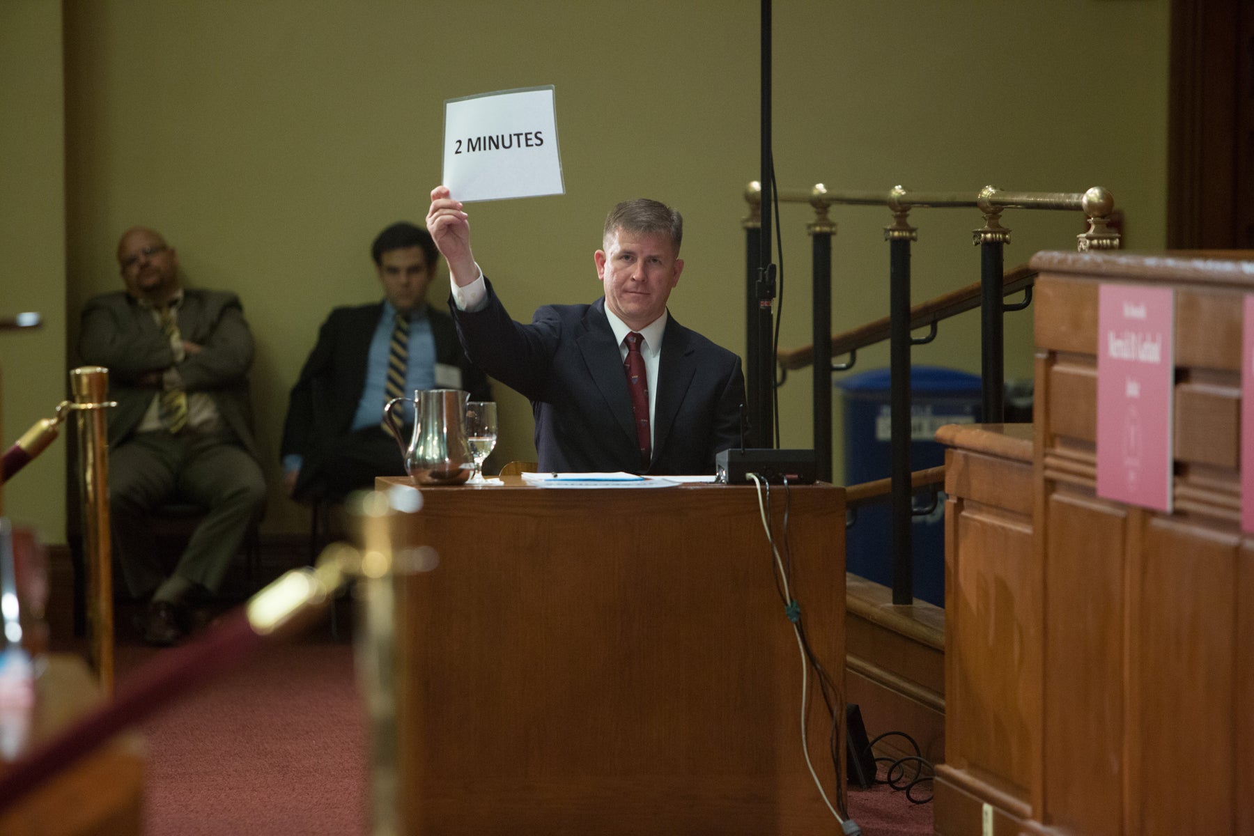 timekeeper holding up a 2 min warning sign