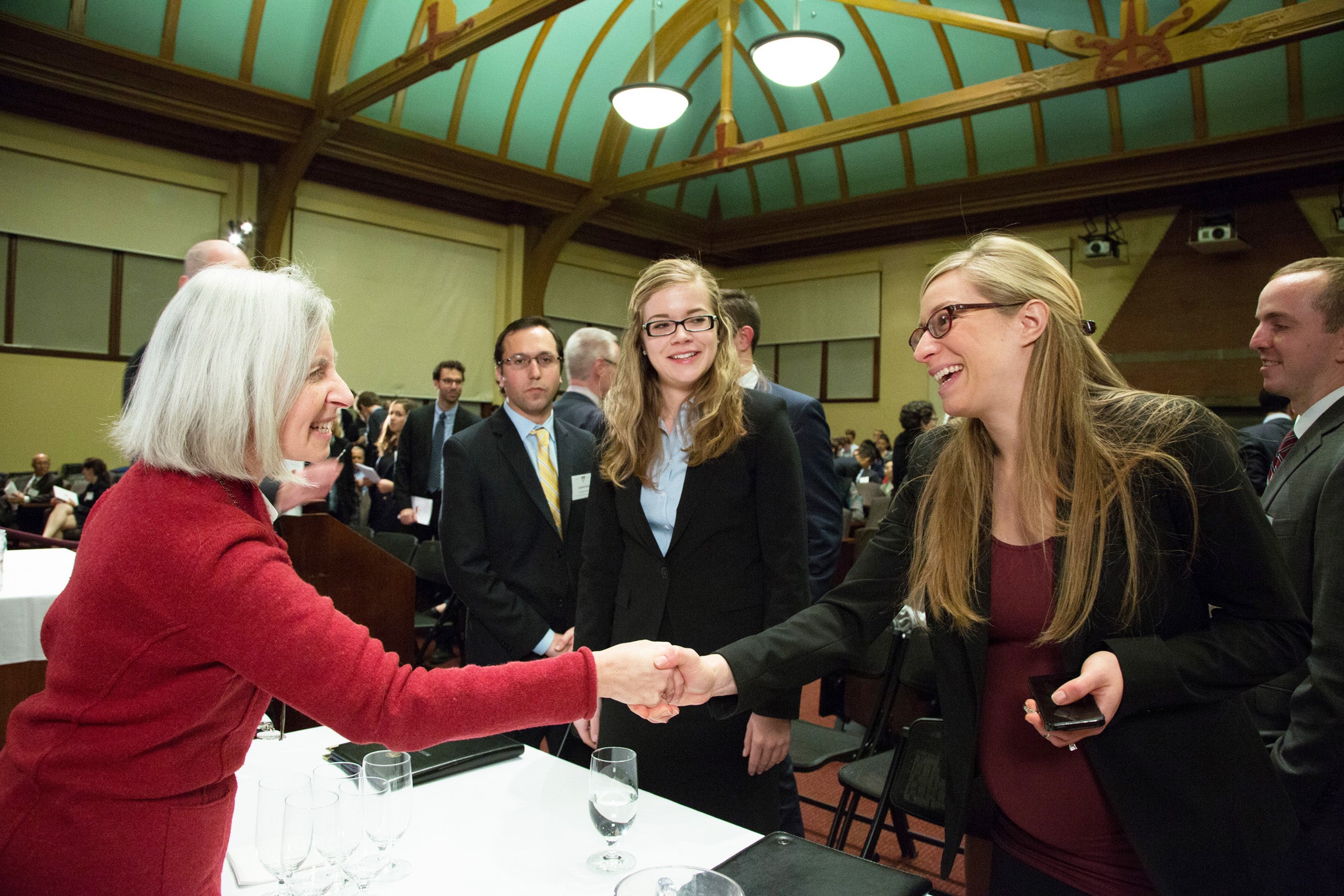 Martha Minow shaking hands with the team