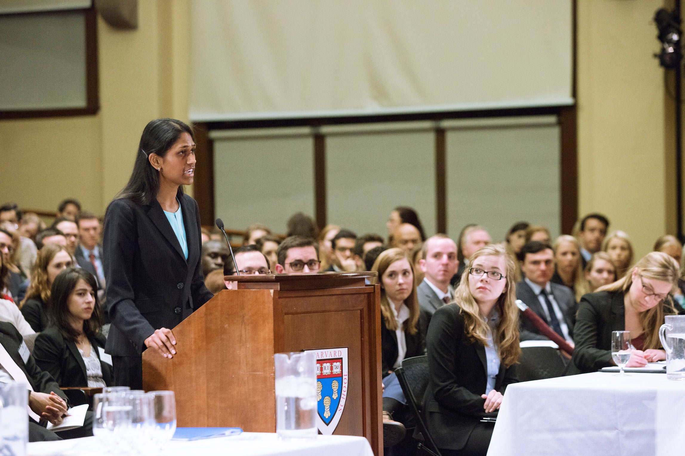 Kavya Naini speaking behind a podium