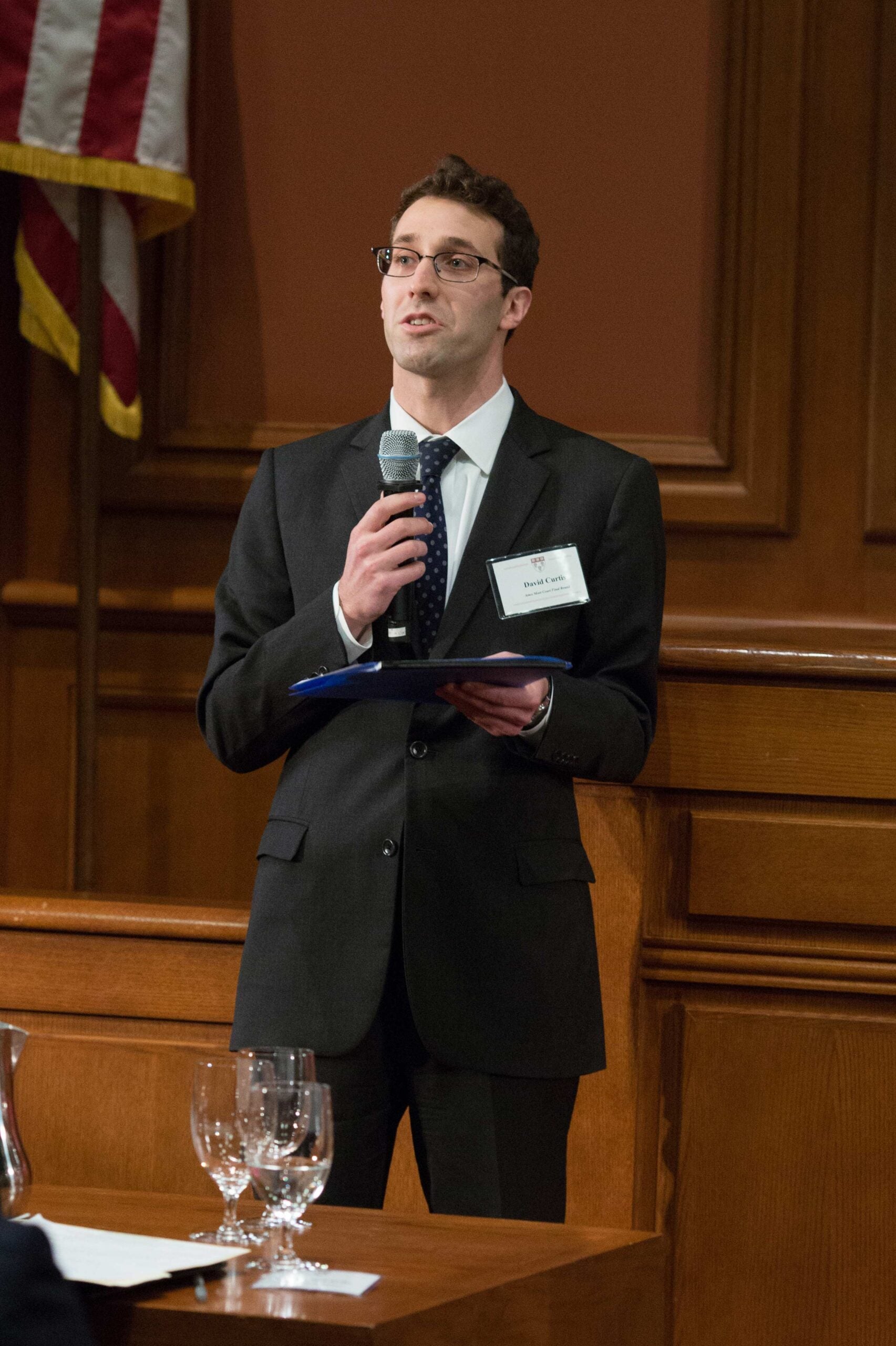 A man standing and speaking into a microphone