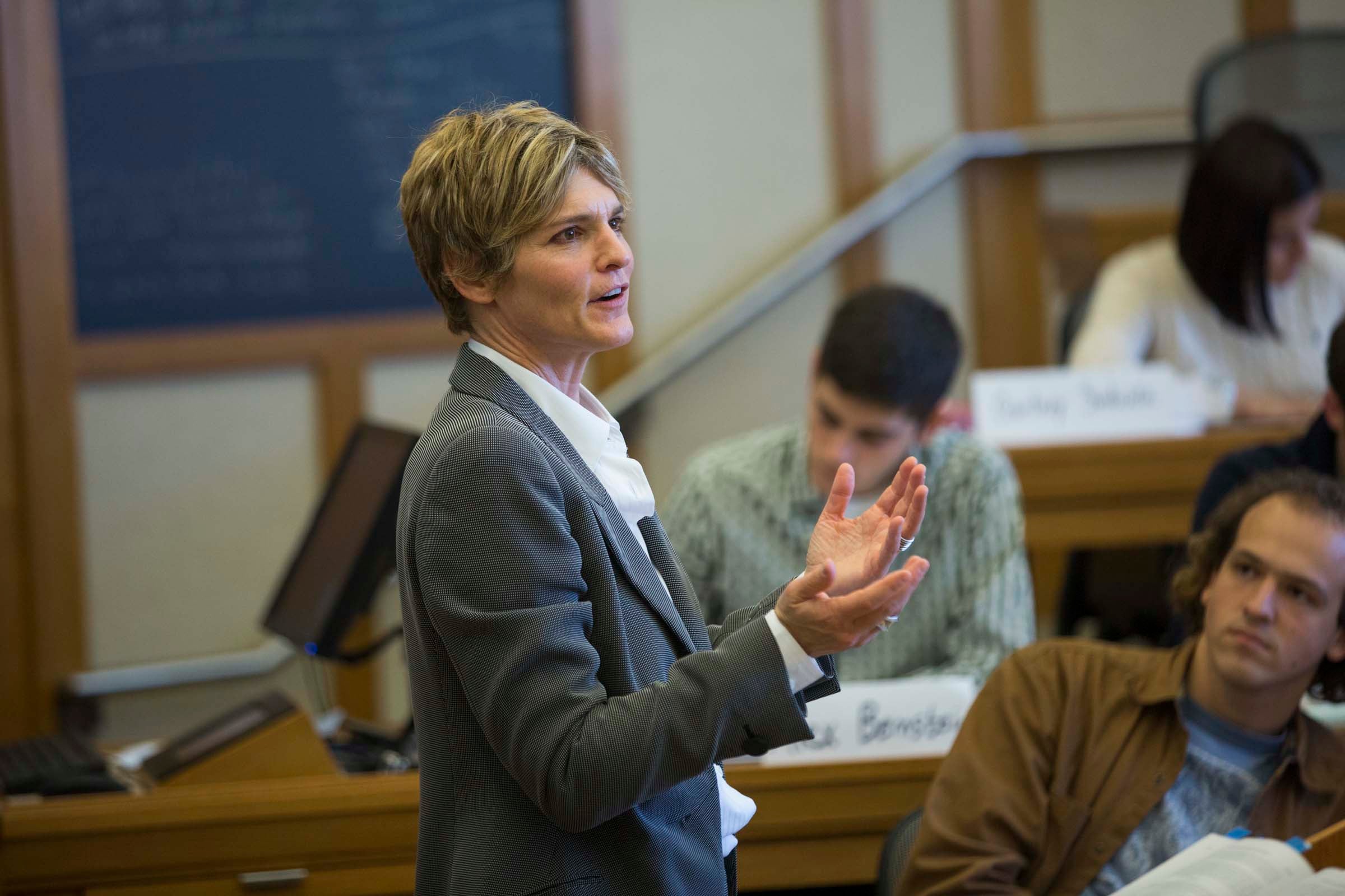 A woman standing at the front of a classroom lecturing