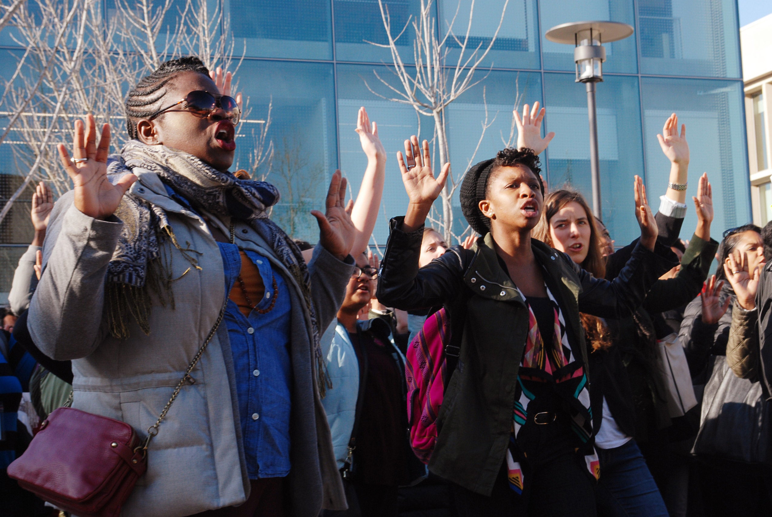Protestors chanting with their arms raised