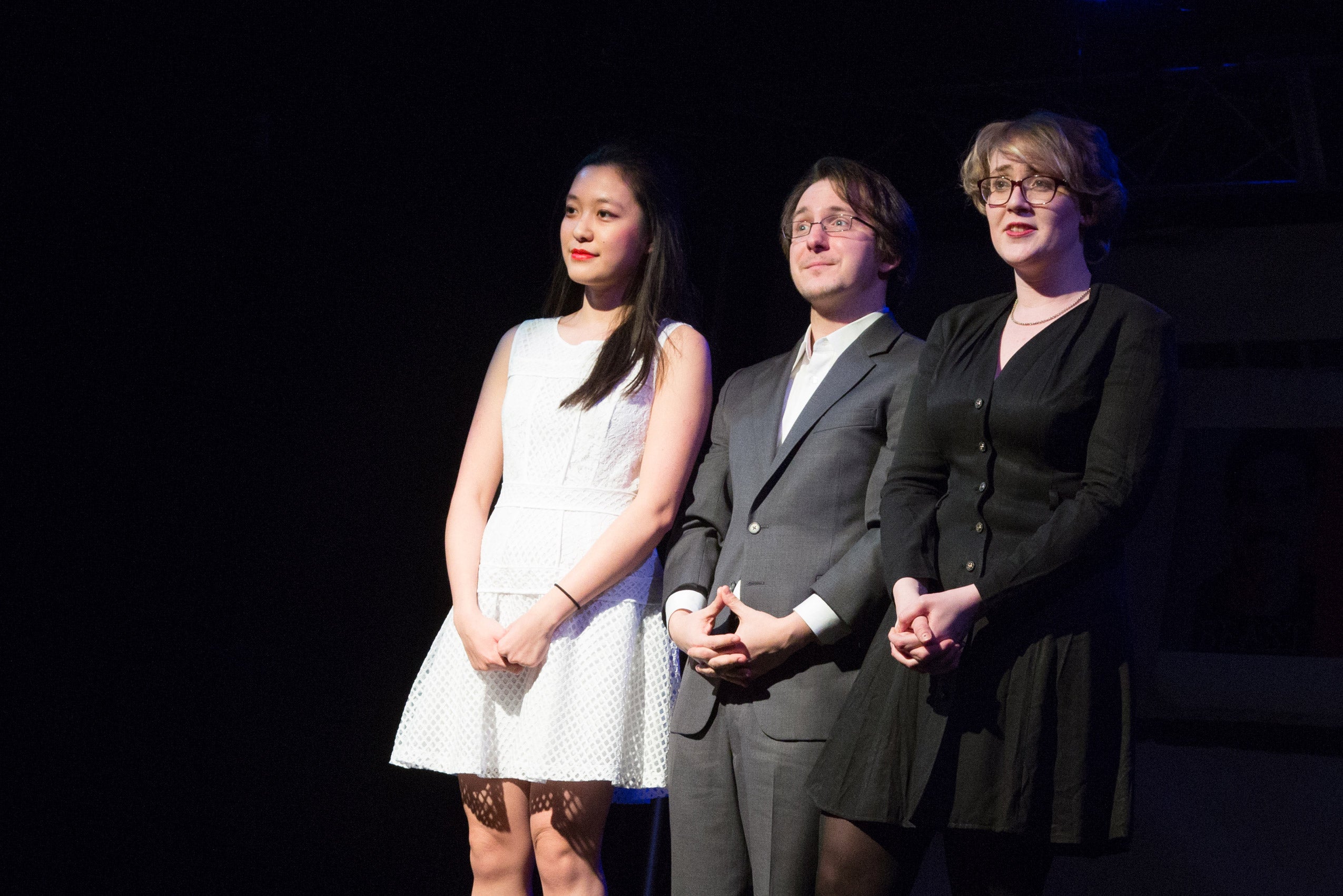 Three people standing on stage