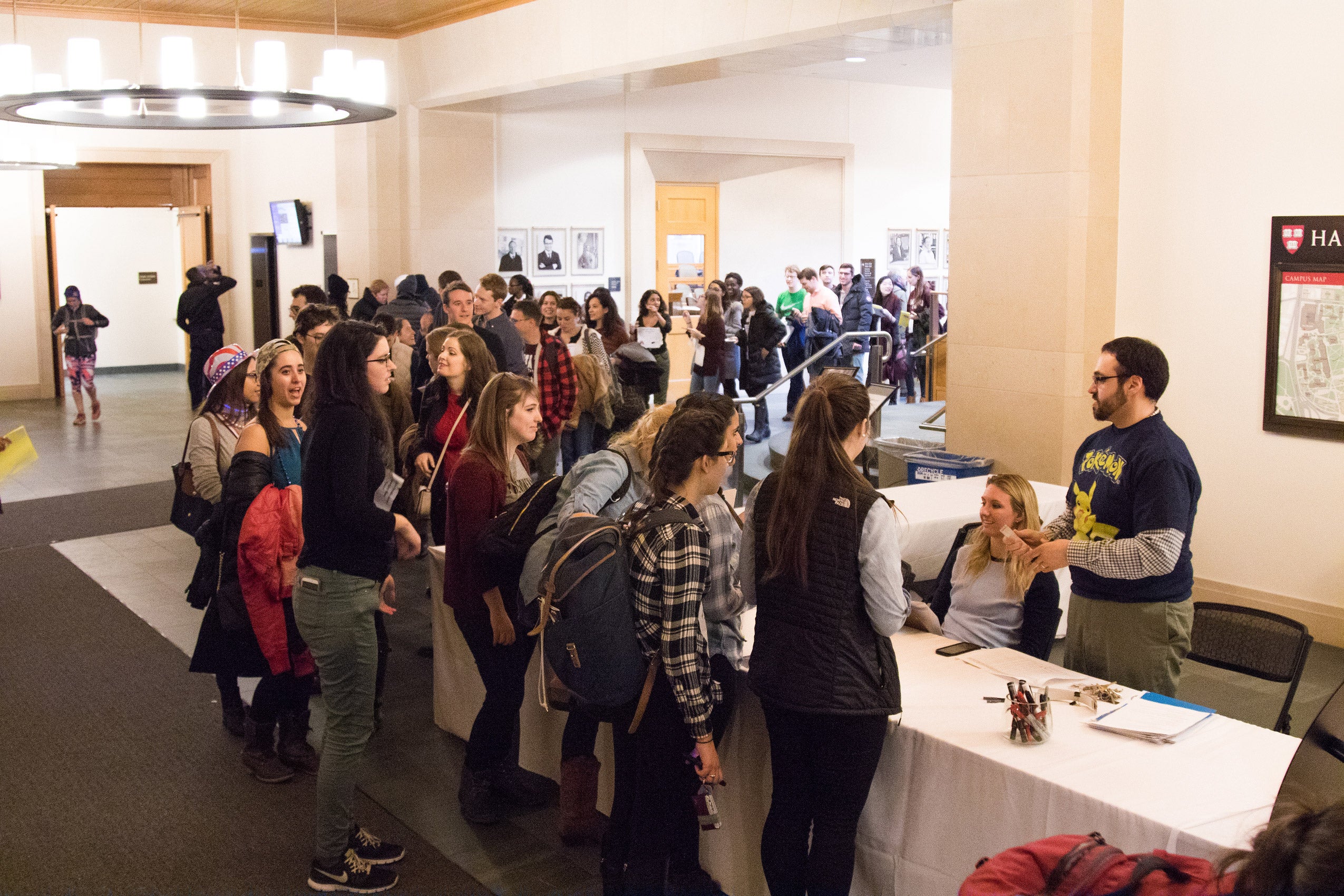 Many students crowding in front of a table in the lobby of the WCC