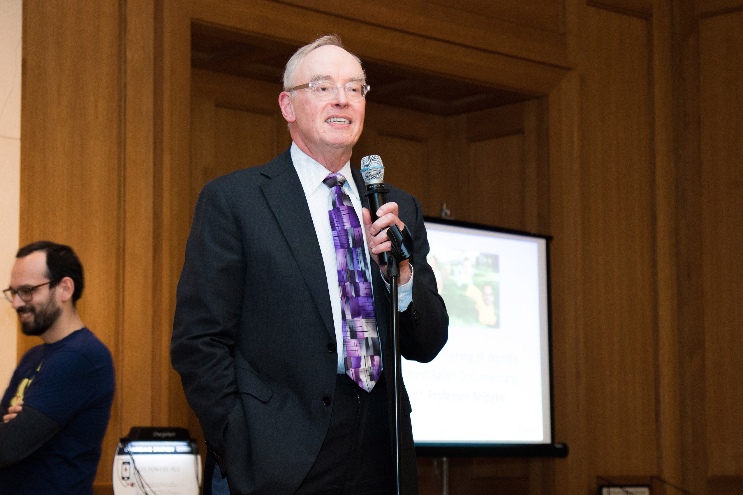 A man holding a microphone, speaking