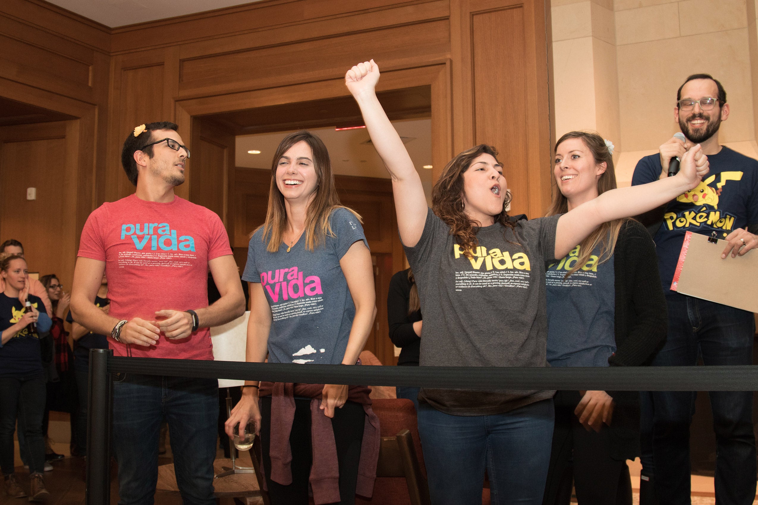 Three women and a man standing and cheering