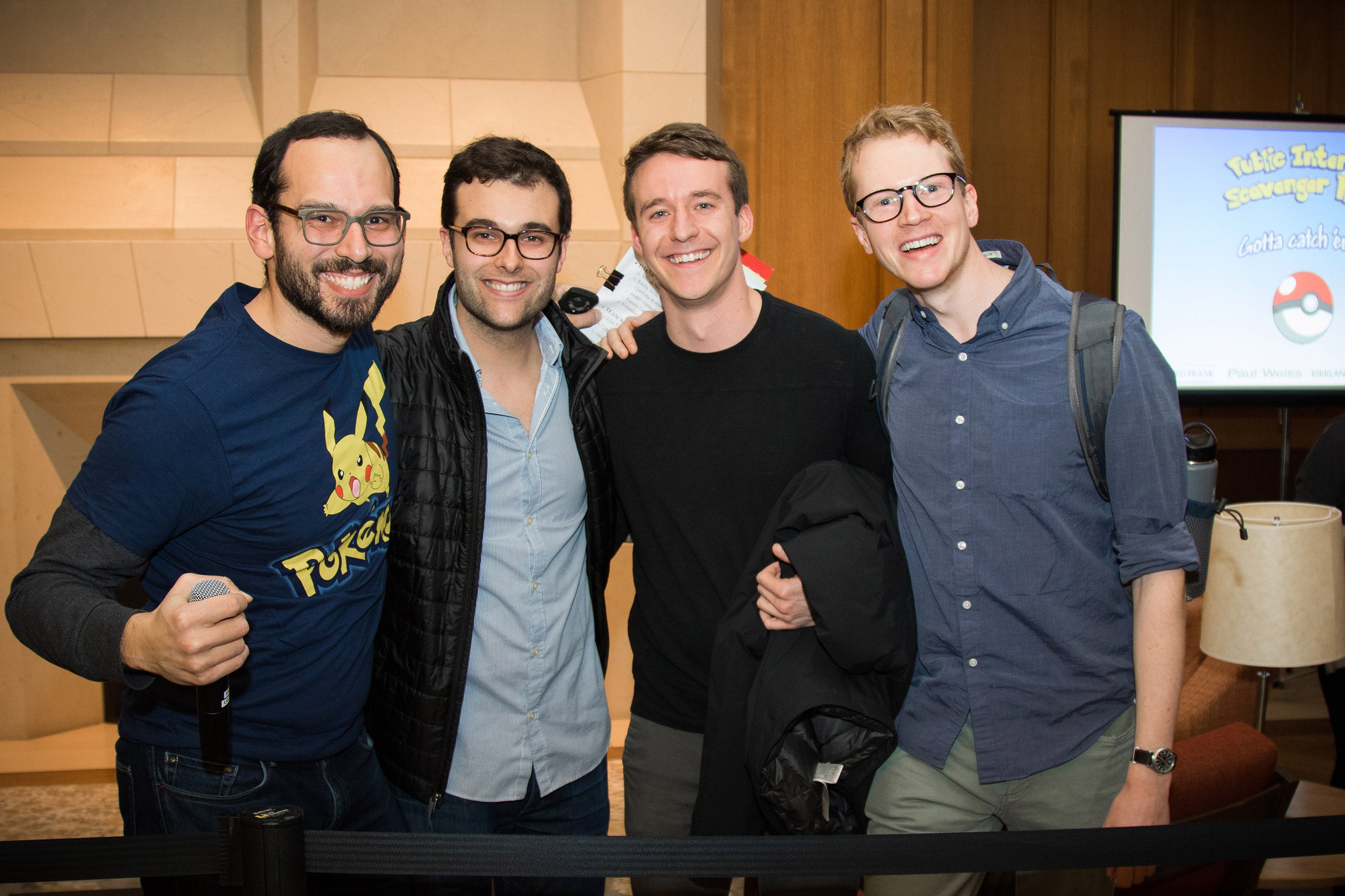 Four men standing together, smiling