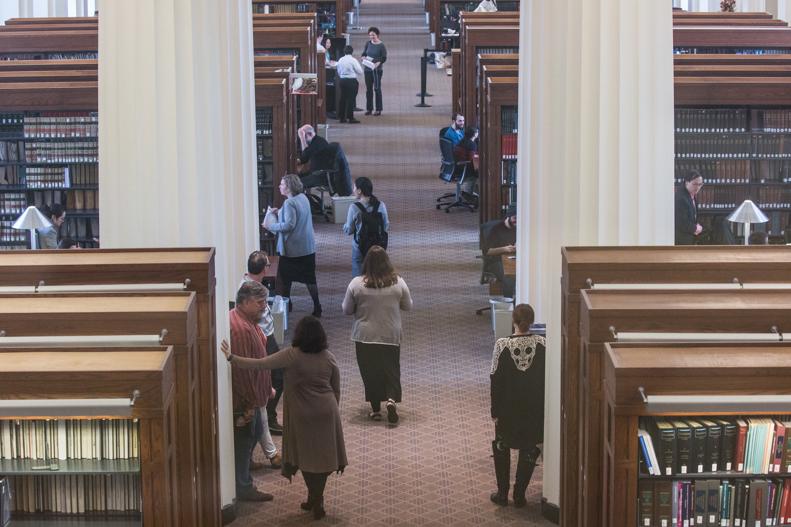 An aerial photo of a library and many people walking around the stacks