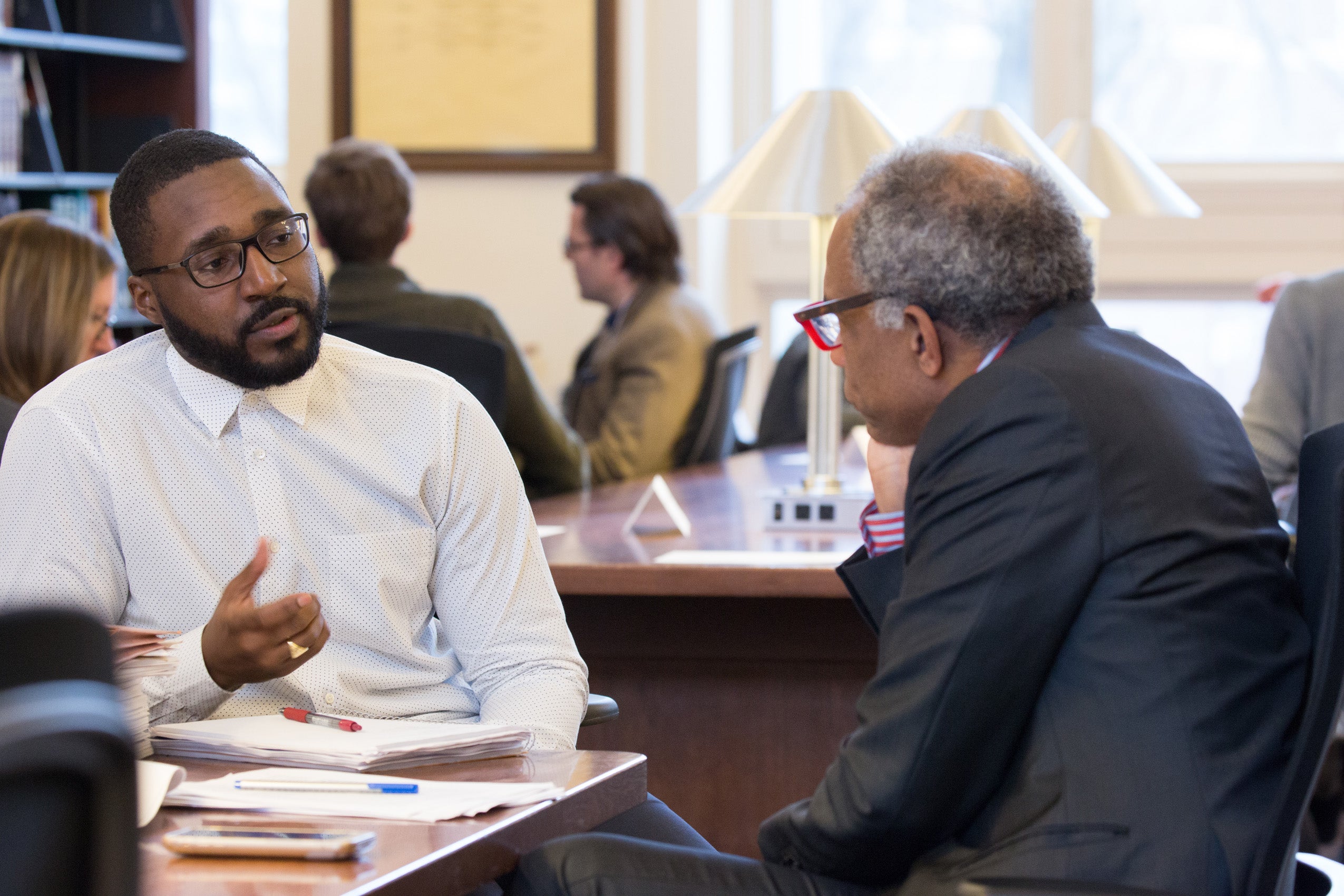 Two men seated at a table having a conversation